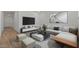 Bright living room featuring a large sectional sofa, modern decor, and wall-mounted TV at 23443 W Albeniz Pl, Buckeye, AZ 85326