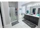 Spacious bathroom featuring a glass-enclosed shower, a soaking tub and double sink vanity with cabinets at 25028 W Wayland Dr, Buckeye, AZ 85326
