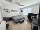 Comfortable bedroom with ceiling fan, neutral walls, decorative shelving and a comfortable workstation at 25028 W Wayland Dr, Buckeye, AZ 85326