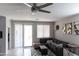 Cozy living room featuring a modern ceiling fan, neutral walls, and a comfortable dark gray sectional sofa at 25028 W Wayland Dr, Buckeye, AZ 85326