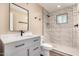 Stylish bathroom with shower, white cabinets, quartz countertop, framed mirror and black matte fixtures at 2540 E Hartford Ave, Phoenix, AZ 85032