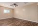 Bright bedroom featuring a ceiling fan, wood flooring, and a window with natural light at 2540 E Hartford Ave, Phoenix, AZ 85032
