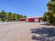 Exterior view of the barn featuring a gated entrance and a gravel parking area at 25829 S Mandarin Dr, Queen Creek, AZ 85142