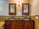 Bathroom featuring a double vanity with granite counters, stone accents and decorative mirrors and lighting at 25829 S Mandarin Dr, Queen Creek, AZ 85142