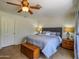 Comfortable bedroom featuring a ceiling fan, wood flooring and two bedside tables with lamps at 25829 S Mandarin Dr, Queen Creek, AZ 85142