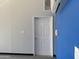 Garage interior with AC unit, white door and painted accent wall at 25829 S Mandarin Dr, Queen Creek, AZ 85142
