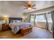 Comfortable main bedroom with a ceiling fan, charming window seat, and stylish furniture on earth tone floors at 25829 S Mandarin Dr, Queen Creek, AZ 85142