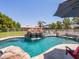Beautiful pool with rock waterfall feature, surrounded by lush landscaping at 25829 S Mandarin Dr, Queen Creek, AZ 85142