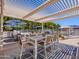 Inviting poolside patio featuring an outdoor dining area, covered pergola, and comfortable seating, perfect for relaxation at 25829 S Mandarin Dr, Queen Creek, AZ 85142
