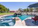 Inviting pool with a rock waterfall feature, adjacent spa, and comfortable seating, creating a tranquil backyard retreat at 25829 S Mandarin Dr, Queen Creek, AZ 85142
