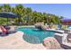 Beautiful swimming pool with a rock waterfall feature, a spa, and comfortable seating, creating a relaxing outdoor oasis at 25829 S Mandarin Dr, Queen Creek, AZ 85142