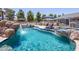 Stunning swimming pool featuring a rock waterfall, comfortable poolside seating, and a serene outdoor ambiance at 25829 S Mandarin Dr, Queen Creek, AZ 85142