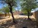Spacious backyard with gravel landscaping, mature trees, and block wall fencing at 272 S 228Th Ln, Buckeye, AZ 85326