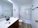 Bathroom featuring a wood vanity, mirror and shower-tub combo at 272 S 228Th Ln, Buckeye, AZ 85326