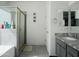 A modern bathroom with a tiled shower, sleek vanity, and a granite countertop at 2723 W Apollo Rd, Phoenix, AZ 85041