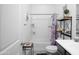 Functional bathroom with a combined shower and tub, storage shelving, and a vanity with a decorative accent table at 2723 W Apollo Rd, Phoenix, AZ 85041