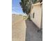 A side view of the backyard with a gravel surface, a green fence, and a block wall at 2937 E Garnet Cir, Mesa, AZ 85204