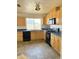 This kitchen features wood cabinets, black appliances, and a window above the sink at 2937 E Garnet Cir, Mesa, AZ 85204