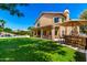 Large backyard with a swimming pool, outdoor kitchen, lush greenery, and seating at 3581 W Ironwood Dr, Chandler, AZ 85226