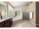 Elegant bathroom features a soaking tub, a glass-enclosed shower, and travertine floors at 3581 W Ironwood Dr, Chandler, AZ 85226