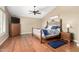 Cozy main bedroom with hardwood floors, ceiling fan, and decorative wooden bed frame at 3581 W Ironwood Dr, Chandler, AZ 85226