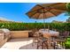 Outdoor kitchen and dining area with a built-in grill, bar seating, and lush surroundings at 3581 W Ironwood Dr, Chandler, AZ 85226
