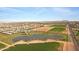 Expansive aerial view showcasing the community's large pond, green spaces, and proximity to farmland and residential areas at 3929 E Bloomfield Pkwy, Gilbert, AZ 85296