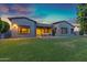 A stunning backyard with a lush lawn, covered patio with seating, hammock, and modern architectural design at 3929 E Bloomfield Pkwy, Gilbert, AZ 85296