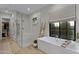 Bathroom featuring a large soaking tub and glass shower with tile accents at 3929 E Bloomfield Pkwy, Gilbert, AZ 85296
