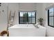 Bright bathroom featuring a soaking tub, window with a view, and a stylish decorative ladder at 3929 E Bloomfield Pkwy, Gilbert, AZ 85296