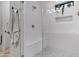 Modern glass-enclosed shower with a built-in seat, unique tiling and decorative plant at 3929 E Bloomfield Pkwy, Gilbert, AZ 85296