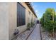 A view of the side of the home featuring a brick walkway, river rock, and drought tolerant shrubs at 3929 E Bloomfield Pkwy, Gilbert, AZ 85296