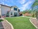 A backyard includes manicured artificial turf and gravel areas with patio seating under a covered porch at 4132 W Tunnel Mine Rd, New River, AZ 85087