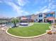 A landscaped backyard features artificial turf, a pool with safety fence and patio umbrellas for shade at 4132 W Tunnel Mine Rd, New River, AZ 85087
