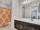 A well-lit bathroom includes dark cabinetry, a sink and mirror, as well as a shower-tub combo with curtain at 4132 W Tunnel Mine Rd, New River, AZ 85087
