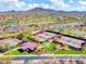 An aerial view shows the tennis courts in this community, with desert landscaping and mountain views in the background at 4132 W Tunnel Mine Rd, New River, AZ 85087