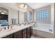 Bright bathroom featuring dual sinks, a soaking tub, and natural light at 4366 E Lexington Ave, Gilbert, AZ 85234