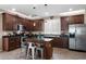 Well-appointed kitchen featuring dark cabinetry, stainless steel appliances, a center island, and a breakfast bar for casual dining at 4366 E Lexington Ave, Gilbert, AZ 85234