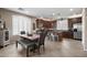 Open kitchen and dining area with dark cabinets, stainless steel appliances, and plantation shutters offering plenty of sunlight at 4366 E Lexington Ave, Gilbert, AZ 85234