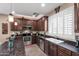 Well-equipped kitchen featuring dark cabinets, stainless steel appliances, granite countertops, and a double basin sink at 4366 E Lexington Ave, Gilbert, AZ 85234