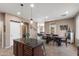 Spacious kitchen with dark cabinets, granite countertops, an island with seating, and seamless flow to adjacent dining and living areas at 4366 E Lexington Ave, Gilbert, AZ 85234