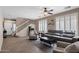 Bright living room with tile floors, plantation shutters, a ceiling fan, and neutral-toned furnishings, bathed in natural light at 4366 E Lexington Ave, Gilbert, AZ 85234