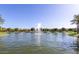 Scenic view of a pond with a fountain, surrounded by lush landscaping and palm trees at 4366 E Lexington Ave, Gilbert, AZ 85234
