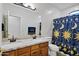 Bathroom featuring double sinks, modern fixtures, and a decorative shower curtain at 4493 E Desert Sands Dr, Chandler, AZ 85249