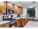 Kitchen area features stainless steel appliances, granite counters and wooden cabinetry at 4493 E Desert Sands Dr, Chandler, AZ 85249