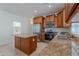 Spacious kitchen featuring wood cabinets, stainless steel appliances, granite countertops, and a center island at 5026 E Sunstone Dr, San Tan Valley, AZ 85143
