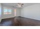 Bright living room featuring dark wood-look flooring, large windows, and a glass door at 5026 E Sunstone Dr, San Tan Valley, AZ 85143