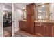 Elegant bathroom with dual vanities, warm wood cabinets, gold-trimmed mirrors, and open closet at 5402 E Larkspur Dr, Scottsdale, AZ 85254