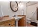 Bathroom with a pedestal sink, custom vanity, and arched entrance to the shower at 5402 E Larkspur Dr, Scottsdale, AZ 85254