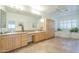 Large bathroom with tile flooring, dual sinks, wood cabinets, a jetted tub, and plantation shutters at 7486 E Bajada Rd, Scottsdale, AZ 85266